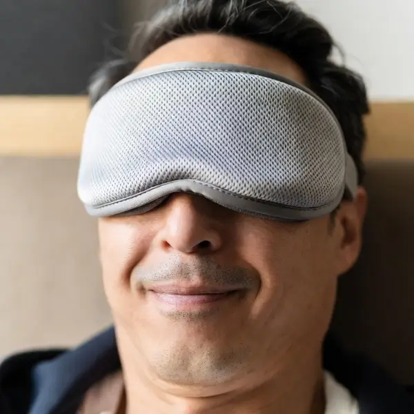 Satisfied customer wearing a cooling eye mask and looking relaxed